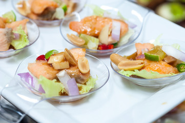 spicy salmon salad snacks on plastic spoons