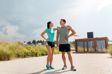 fitness, sport and lifestyle concept - happy couple in sports clothes outdoors