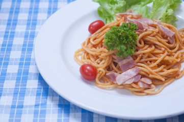 close up of delicious spaghetti with bacon and tomatoes on white plate and , Select focus