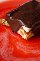 cheesecake with chocolate in white plate with strawberry red syrup. Dew drops Macro photo.