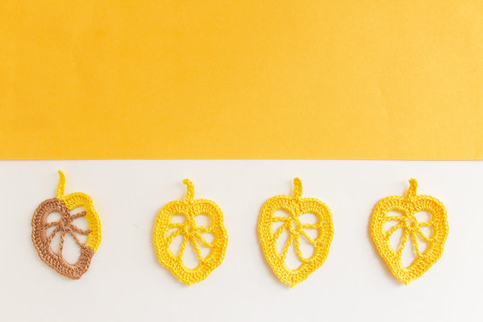 Autumn crochet leaves on a white background. Background layout with free text space yellow.