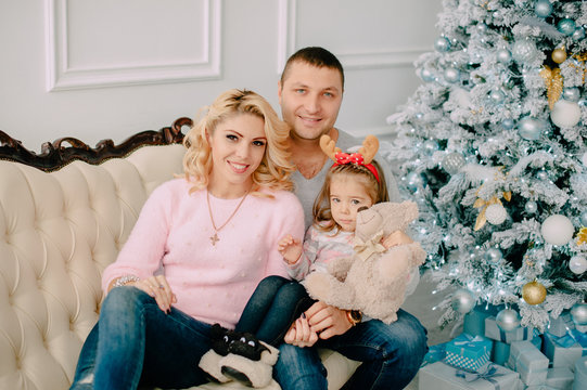 portrait of young happy family near Christmas tree