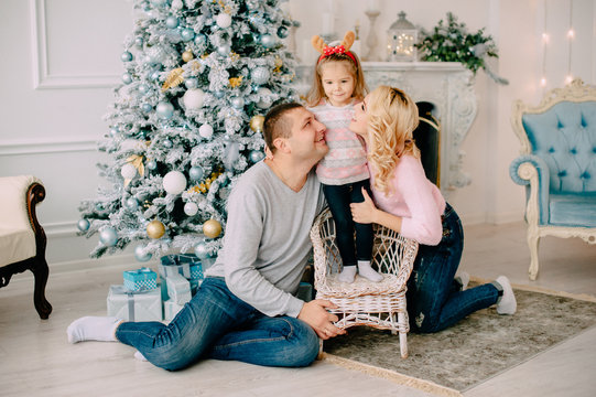 portrait of young happy family near Christmas tree
