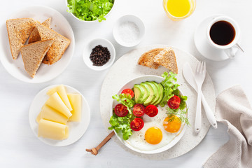 healthy breakfast flat lay. fried eggs, avocado, tomato, toasts and coffee