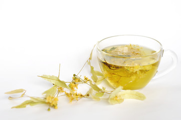 Photo of herbal tea in a transparent cup. flowers and leaves of herbs. flowers of linden and elderberry, leaves of mint. time for relaxation. hot tea. use for background, text, for your design, card