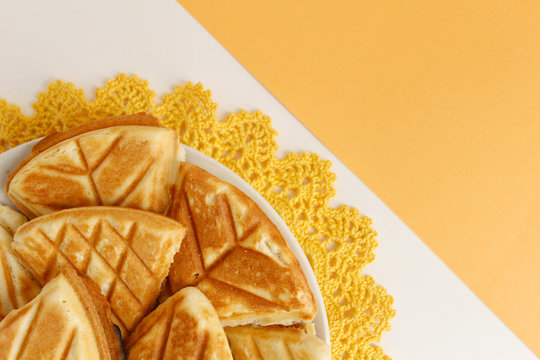 Homemade cookies, handmade on a yellow crocheted napkin. White and yellow background. Background layout with free space for text. The concept of a warm home, comfort.