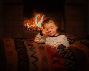 toddler sitting in bean bag at fireplace