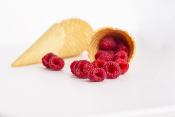 Ice cream or delicious dessert made from fresh raspberry berries on white background. Raspberry in a waffle cone. Summer, freshness, and the concept of the sweet menu.