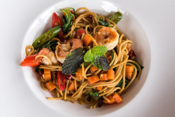 Spaghetti with spicy prawn in white dish.