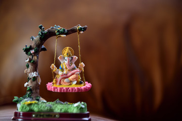 Hindu God-Ganesha in art form sitting on a swing. Hindu Lord Ganesha provide success, prosperity...