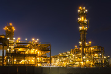 Night industrial landscape with bright lights of lanterns - fluid catalytic cracking unit (FCC) in...