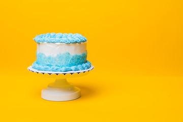 White and blue cake with yellow background