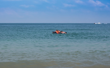 The boys lie on an inflatable mattress in the sea