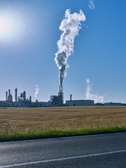 Chemical Industry / Boehlen / Germany: View over a mowed field to a modern chemical plant with cracker in the early morning sun