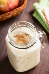 Fresh homemade vegan apple, oatmeal and chia seed smoothie with cinnamon on top, served in mason jar (Selective Focus, Focus in the middle of the image)