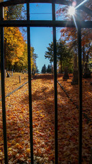 SOUTHBRIDGE, MASSACHUSETS. USA - NOVEMBER 17 2017. View of an old cemetery and graves trough the gate bars in Autumn fall halloween