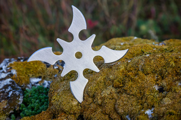 Shuriken (throwing star), traditional japanese ninja cold weapon stuck in wooden background