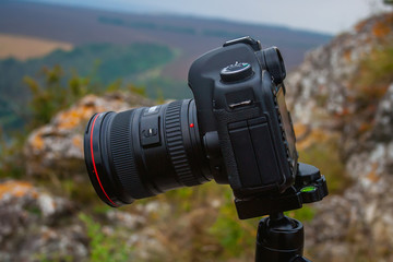 Camera on a tripod outdoors in summer.
