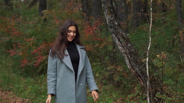 beautiful young brunette girl walking in the Park in autumn.
