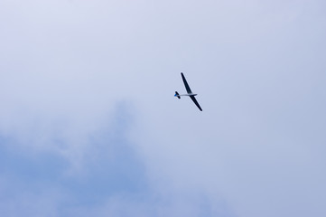 Glider in flight with cloudy sky