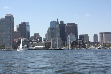 Fototapeta na wymiar Boston Skyline Seen From the Harbor. The skyline of Boston as see from the middle of the Boston Harbor. The historical `Custom House Tower` is the pointed building with the clock on it.