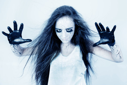 possessed by spirits, a girl with bruises under her eyes and black veins conjures her hands. concept of halloween and day of the dead.