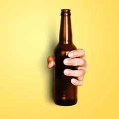 Hand of young man holding brown bottle