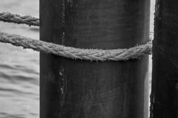 An old rope tied around a metal pipe