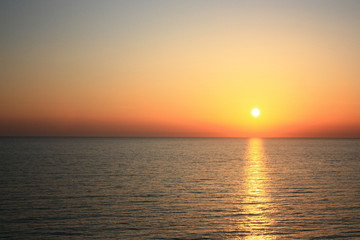 Sea sunset. Orange sun. Summer warm evening view from the cliffs to the sea.