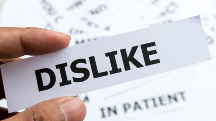 Disike text or word meaning on paper in hand holding