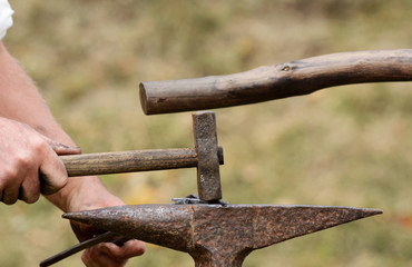 Close-up of man's hand using a rustic hammer