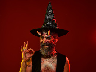 Halloween man with devil horns in witch hat show ok