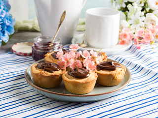 Cakes with frangipane, cherry jam and chocolate frosting. Romantic table setting with flowers. Mother's day card