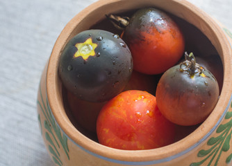 Dark red tomatoes in clay pot