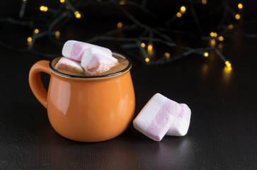 Cocoa in an orange mug on a black background.