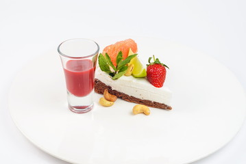Cheesecake with strawberries, citrus, cashew nuts and sauce