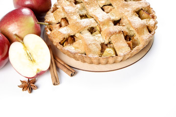 Traditional American Thanks Giving pie, whole & halved apples, cinnamon sticks, anise seeds. Homemade fruit tart baked to golden crust with ingredients. Close up, copy space, top view, background.