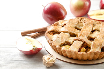 Traditional American Thanks Giving pie, whole & halved apples, cinnamon sticks, anise seeds. Homemade fruit tart baked to golden crust with ingredients. Close up, copy space, top view, background.
