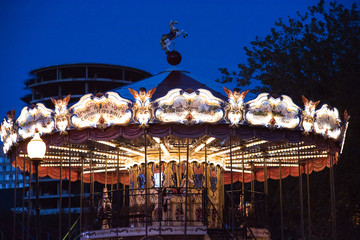 Children's Carousel at an amusement park in the evening and night illumination. amusement park at...