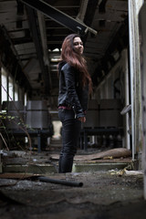 portrait Young woman with long grounge red hair posing in an abandoned place full of graffity