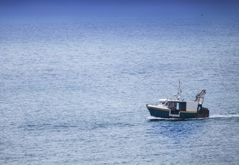 Fototapeta premium Homecoming: Tired fishermans ship approaching after a hard day