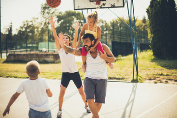 Family playing basketball together.