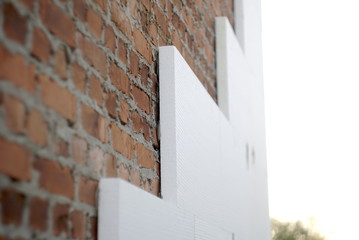 insulation of a brick wall with polystyrene white - obrazy, fototapety, plakaty