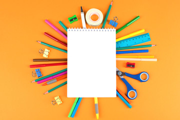 School office supplies on orange background