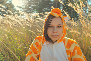 Funny giraffe costume, Emotional girl in funny pajamas sitting in a field of wheat. Concept...