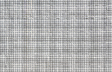 Wall covered in small white tiles texture