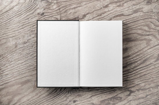 Mockup of opened blank book on vintage wood table background. Flat lay.