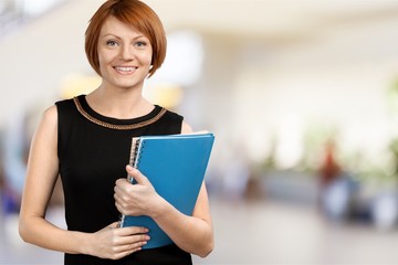 Close-up portrait of cute woman with notebook