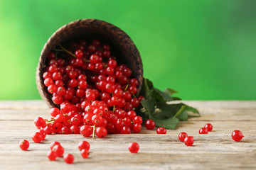 Red currants in wicker basket on grey wooden table