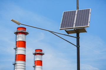 Public city light with solar panel powered on blue sky with clouds